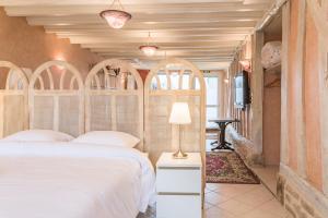 una camera con un letto bianco con testiera ad arco di Le RUBIS - Confort - Proche Mag Outlet Troyes - Parking gratuit a Pont-Sainte-Marie