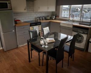 een keuken met een tafel en stoelen en een keuken met een wastafel bij Apartment 4, Cornerhouse Apartments in Llandudno