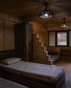 een kamer met een bed en een trap in een hut bij Cottage Tsivtskala in Racha, near Shaori in Kʼveda Tʼlughi