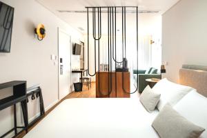 a bedroom with a large white bed with a chandelier at MouraSuites Hotel in Évora