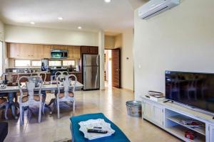 a living room with a dining table and a kitchen at Aldea Zama Penthouse with Private Rooftop in Tulum +49 photos