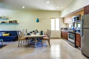 a kitchen with a table and chairs and a refrigerator at Aldea Zama Penthouse with Private Rooftop in Tulum