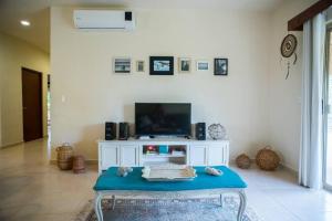 a living room with a tv and a table at Aldea Zama Penthouse with Private Rooftop in Tulum