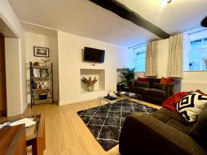 a living room with a couch and a tv at Superbly located 2 bedroom luxury apartment in Bath