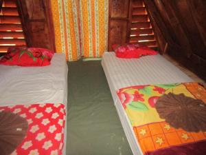 two beds in a room with water in it at Balian Camp in Tuk Tuk