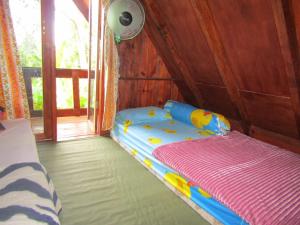 a childs bed in a room with a window at Balian Camp in Tuk Tuk