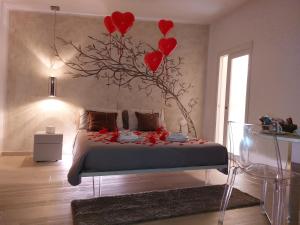 Un dormitorio con un árbol con corazones rojos. en Suite Amnesia, en Mesagne