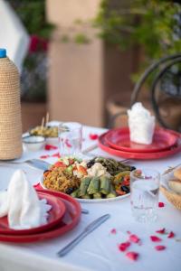 una mesa con platos rojos de comida. en Riad Mur Akush, en Marrakech