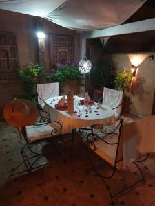un tavolo da pranzo con sedie in una stanza con tavolo e sedie a sdraio di Riad Mur Akush a Marrakech
