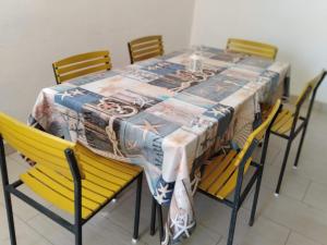 a dining room table with yellow chairs and a table cloth at Apartments Lalić - Two bedroom ground floor apartment close to the beach in Tučepi