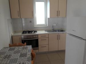 a kitchen with a sink and a stove and a table at Biserka in Novalja