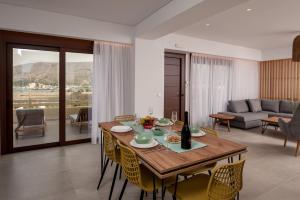 a living room with a wooden table and chairs at Thyme Sea View Apartments in Souda