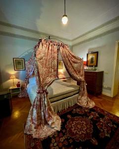 a bedroom with a bed with a canopy at Villa la Moresca Relais de Charme BeB Adults only in Montecatini Terme