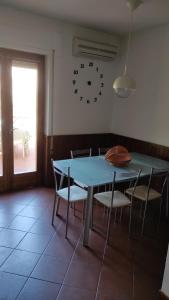 a dining room table with chairs and a clock on the wall at Sea Breeze in Viareggio