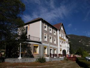 - un grand bâtiment avec des chaises devant dans l'établissement Hôtel Lac Et Forêt, à Saint-André-les-Alpes