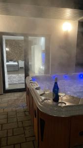 La salle de bains est pourvue d'une baignoire et de 2 verres à vin. dans l'établissement Malibu Apartman & Jacuzzi, à Miskolctapolca