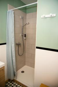 La salle de bains est pourvue d'une douche avec rideau de douche. dans l'établissement Cosy Green Clim Wifi Centre ville 2 pers, à Lézignan-Corbières
