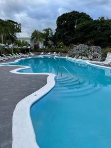 a large swimming pool with blue water and chairs at Jamaica Palace Hotel in Port Antonio