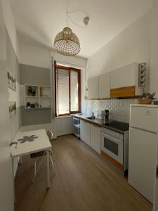 Una cocina con gabinetes blancos y una mesa en ella. en Casetta di Mari, CinqueTerreCoast, en Chiavari
