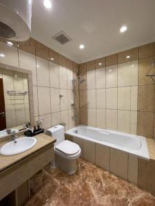 a bathroom with a tub and a toilet and a sink at فندق وريف الشرق in Sarat Abidah