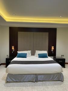 a large bed in a hotel room with blue pillows at فندق وريف الشرق in Sarat Abidah +30 photos