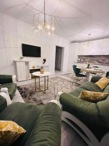 uma sala de estar com um sofá verde e uma mesa em Apartament Larysse em Oradea
