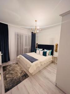um quarto com uma cama grande e um lustre em Apartament Larysse em Oradea