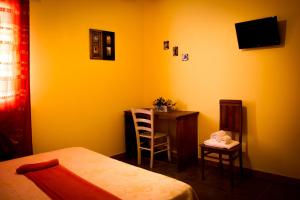 a bedroom with a bed and a desk and a chair at B&B Kilometrozero in Supersano