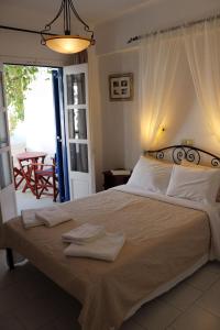 1 dormitorio con 1 cama grande y toallas. en Pension Ilias - Chora Amorgos, en Amorgós