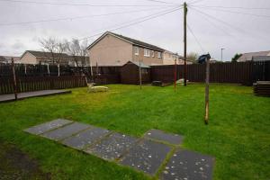 a yard with a fence and a bench in the grass at PREMIER - Chapel Street Apartment in Cleland