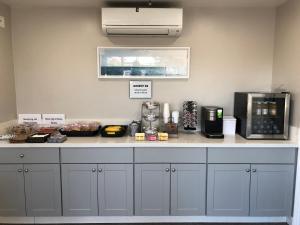 a kitchen with a counter with a coffee maker at University Inn at San Luis Obispo in San Luis Obispo +21 photos
