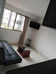 - un salon avec un canapé et une table dans l'établissement Arriendo hermoso y amplio apartamento amoblado y con piscina, frente a la estación Niquia y al centro comercial puerta del norte., à Bello