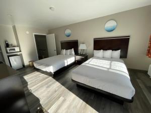 una camera d'albergo con due letti e specchi blu di University Inn at San Luis Obispo a San Luis Obispo