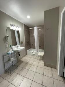 ein Bad mit einer Badewanne, einem Waschbecken und einer Dusche in der Unterkunft University Inn at San Luis Obispo in San Luis Obispo