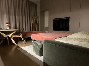 a hotel room with a bed and a tv at Pink Peony in Druskininkai +5 photos