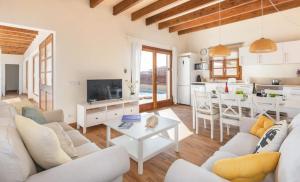 a living room with a white couch and a table at Villas Sa Ferradura in Cala en Blanes