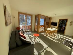 ein Wohnzimmer mit einem Sofa und einem Tisch in der Unterkunft Selva Mountain Apartment in Flims