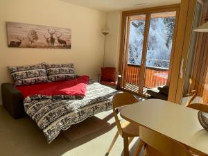 a bedroom with a bed and a table and a window at Selva Mountain Apartment in Flims