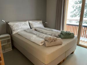 1 cama con 2 toallas y ventana en Selva Mountain Apartment, en Flims