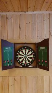 a dart board on a wall with two books at Rolig og idyllisk, men sentralt i Kristiansand in Kristiansand