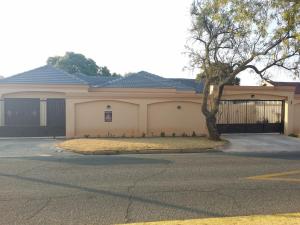 a house with a tree in front of a garage at Alicia's B&B in Roodepoort