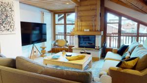 ein Wohnzimmer mit 2 Sofas und einem TV in der Unterkunft Résidence Le Lys Martagon in Val dʼIsère