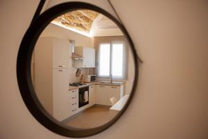 - une cuisine avec des placards blancs et un miroir dans l'établissement Agorà Home, à Terrasini