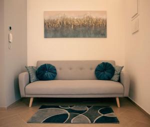 a couch in a living room with a painting on the wall at Agorà Home in Terrasini