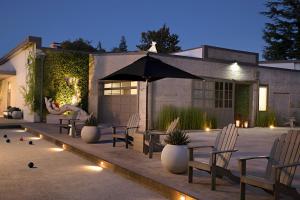 a patio with chairs and an umbrella and plants at R Inn Napa in Napa