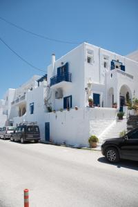 a white building with cars parked in front of it at Katerina Rooms in Naousa