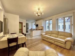 sala de estar amplia con sofá y mesa en Milne Apartments, en San Petersburgo