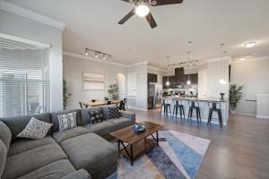 ein Wohnzimmer und eine Küche mit einem Sofa und einem Tisch in der Unterkunft Luxury Townhomes - Evonify Stays in Austin