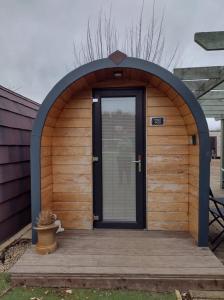 an arched entryway to a wooden building with a door at Goldenhill Retreats in Bamburgh