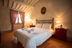 une chambre avec un grand lit avec des serviettes dessus dans l'établissement Podere San Pietro Resort, à Castiglion Fibocchi 46 autres photos
